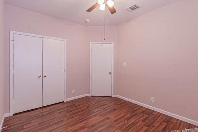 unfurnished bedroom featuring visible vents, a closet, baseboards, a ceiling fan, and dark wood finished floors