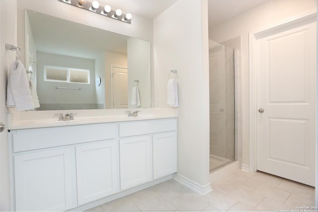full bath with tile patterned floors, a shower stall, and a sink