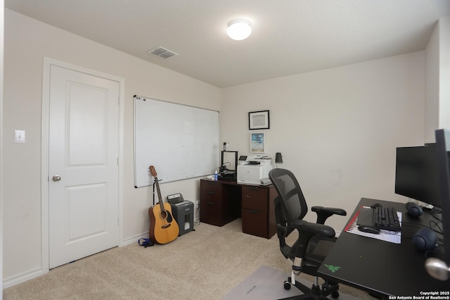 office space with baseboards, visible vents, and light carpet