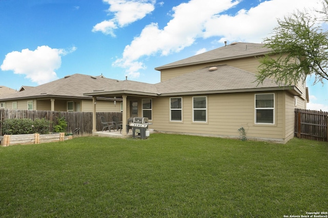 rear view of house featuring a garden, a patio, a fenced backyard, a shingled roof, and a lawn