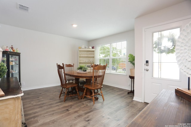 dining space featuring dark wood-style flooring, baseboards, and visible vents