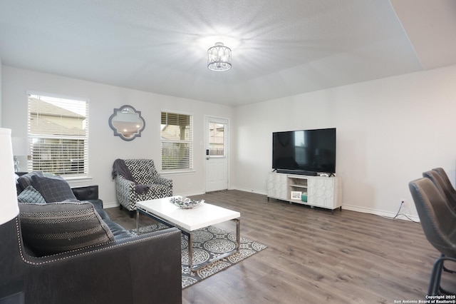 living area with baseboards and wood finished floors