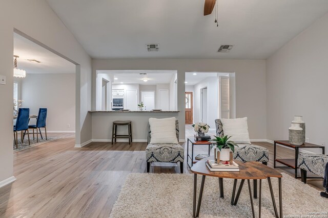 sitting room with baseboards, wood finished floors, and visible vents