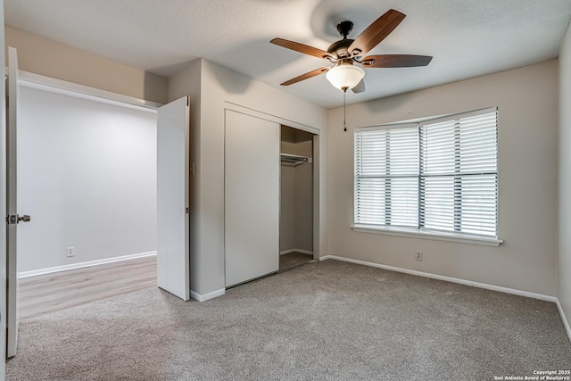 unfurnished bedroom featuring carpet floors, a ceiling fan, baseboards, and a closet