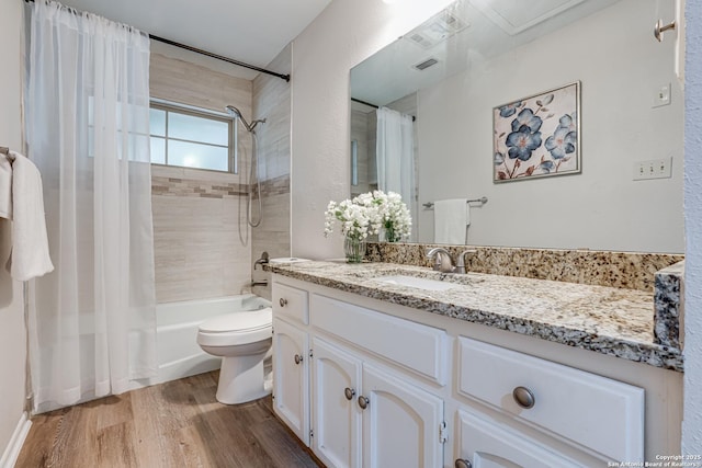 full bathroom featuring visible vents, wood finished floors, vanity, toilet, and shower / tub combo with curtain
