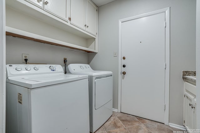 clothes washing area with baseboards, cabinet space, and washing machine and clothes dryer