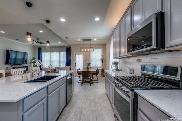 13911 Lazada, San Antonio, TX 78245 - kitchen with appliances with stainless steel finishes, a sink, open floor plan, gray cabinets, and tasteful backsplash