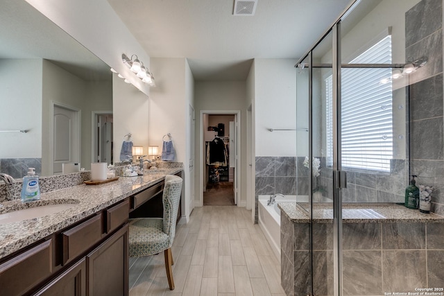 13911 Lazada, San Antonio, TX 78245 - bathroom featuring plenty of natural light, vanity, a garden tub, and a shower stall