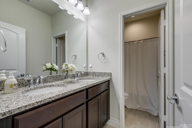 13911 Lazada, San Antonio, TX 78245 - bathroom featuring double vanity, toilet, and curtained shower