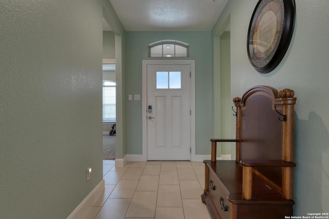 9407 Sundrop Vly, San Antonio, TX 78254 - foyer featuring baseboards, a textured wall, and light tile patterned floors