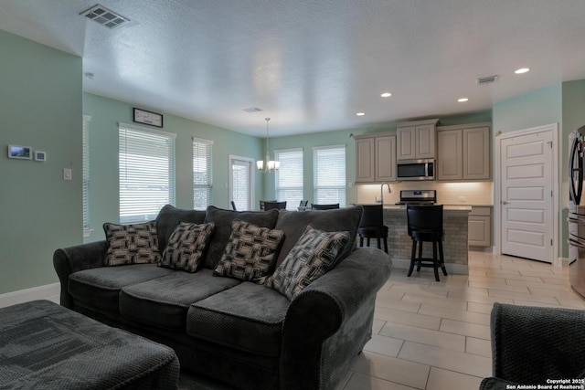 9407 Sundrop Vly, San Antonio, TX 78254 - living area featuring an inviting chandelier, recessed lighting, and visible vents