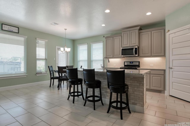 9407 Sundrop Vly, San Antonio, TX 78254 - kitchen with tasteful backsplash, a healthy amount of sunlight, a breakfast bar, and stainless steel appliances