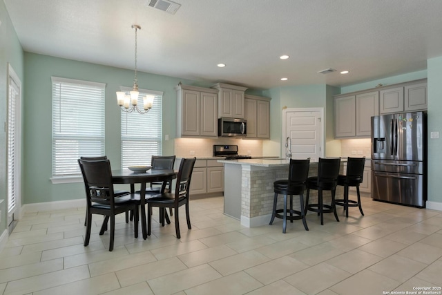 9407 Sundrop Vly, San Antonio, TX 78254 - kitchen with visible vents, decorative backsplash, a chandelier, gray cabinetry, and stainless steel appliances