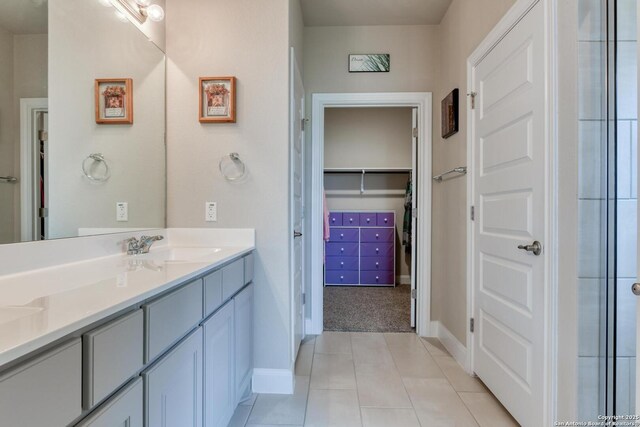 9407 Sundrop Vly, San Antonio, TX 78254 - bathroom with baseboards, a spacious closet, tile patterned flooring, and vanity