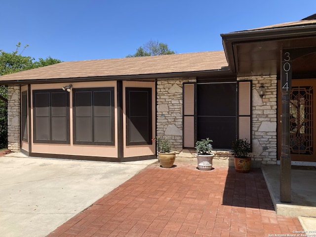 3014 War Knife, San Antonio, TX 78238 - entrance to property with a shingled roof, a patio area, and stone siding