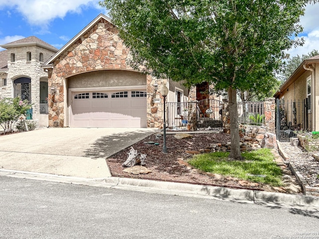 view of front of house with a garage, fence, stone siding, stucco siding, and driveway