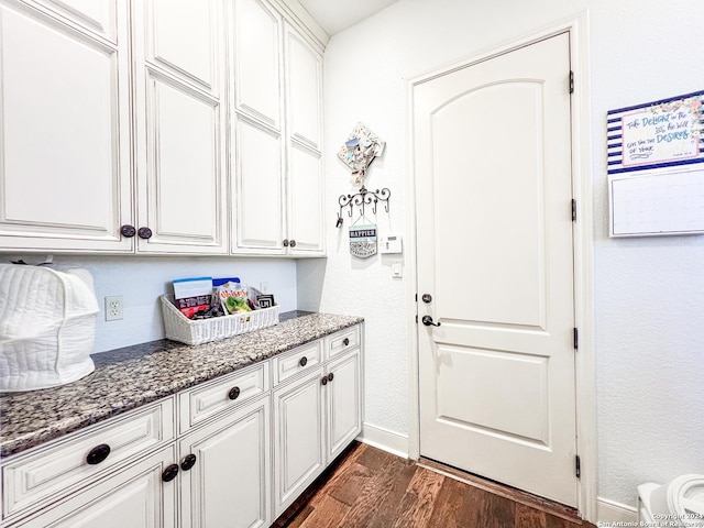 interior space with baseboards and dark wood-type flooring
