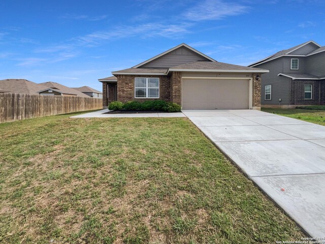 single story home featuring fence, a front yard, brick siding, concrete driveway, and an attached garage