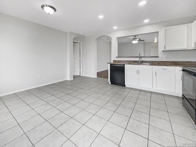 kitchen featuring ceiling fan, arched walkways, dark countertops, a sink, and black appliances