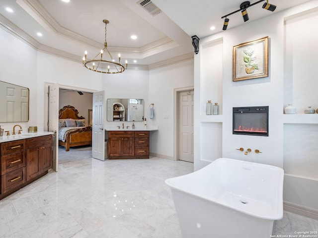4 Waterford Gln, San Antonio, TX 78257 - full bathroom featuring marble look tiles, two vanities, a chandelier, a freestanding bath, and a glass covered fireplace
