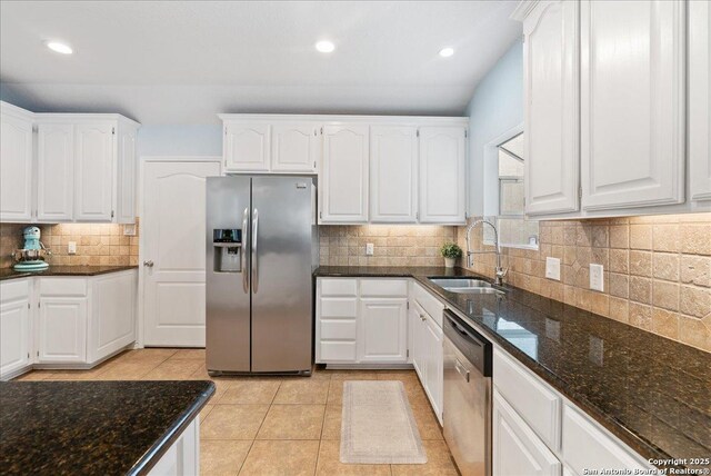 kitchen featuring a sink, dark stone counters, appliances with stainless steel finishes, and tasteful backsplash
