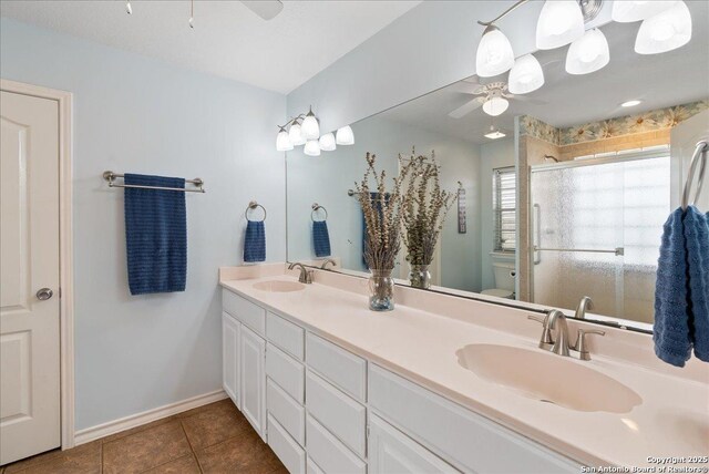 bathroom featuring ceiling fan, a sink, and tile patterned flooring