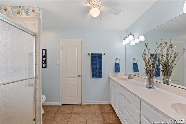 bathroom with a sink, tile patterned flooring, double vanity, a ceiling fan, and a shower stall