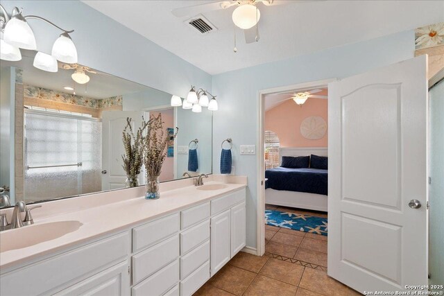 ensuite bathroom featuring ceiling fan, visible vents, a sink, and tile patterned floors