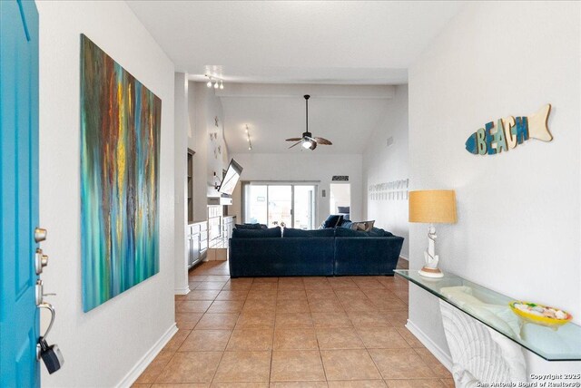 living room featuring baseboards, ceiling fan, lofted ceiling, and light tile patterned floors