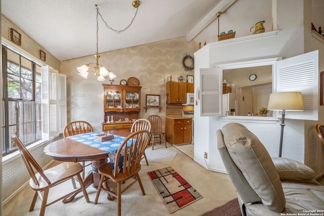 dining area with light colored carpet, wallpapered walls, and an inviting chandelier