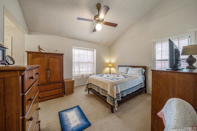 bedroom featuring a ceiling fan, a textured ceiling, vaulted ceiling, and light carpet