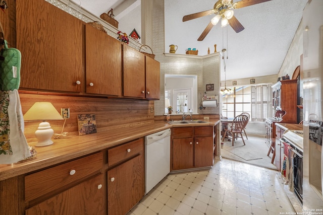 kitchen with brown cabinets, white dishwasher, stove, and ceiling fan with notable chandelier
