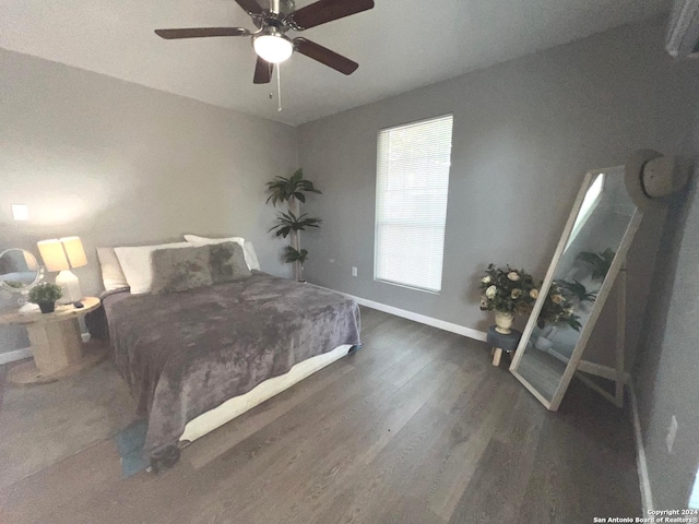 bedroom with baseboards, ceiling fan, and wood finished floors