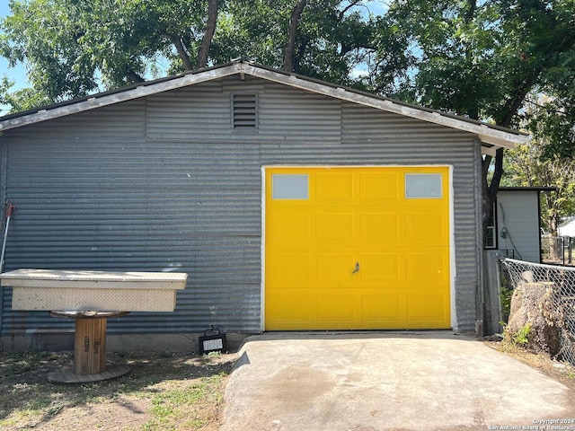 detached garage with fence and driveway