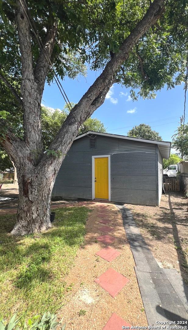 view of outbuilding featuring fence and an outdoor structure
