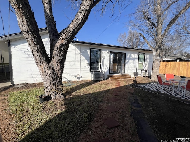 rear view of house featuring a patio and fence