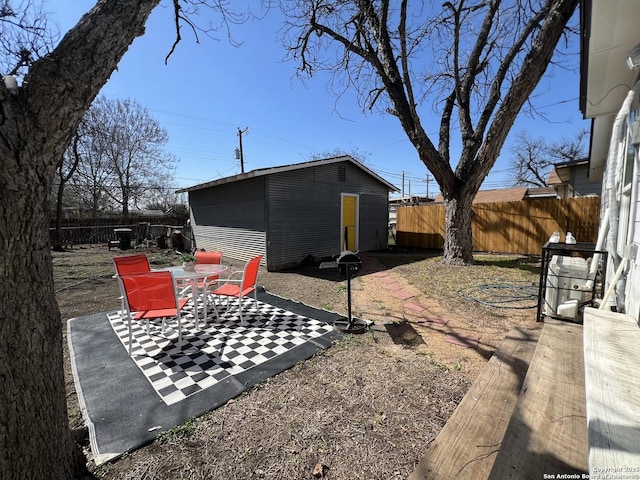 view of yard featuring an outbuilding, fence private yard, and a patio area