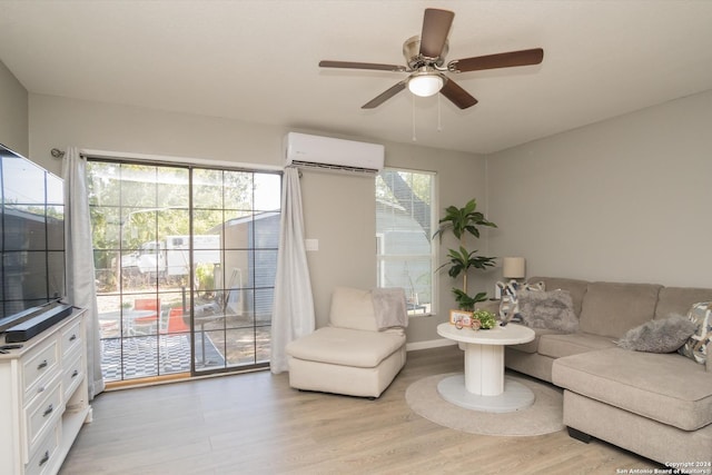 living area featuring light wood-type flooring, a wall mounted air conditioner, baseboards, and a ceiling fan