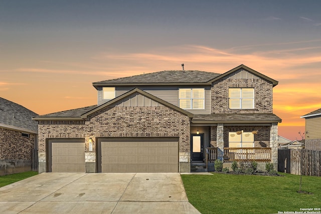 view of front of house with covered porch, driveway, a garage, fence, and a yard