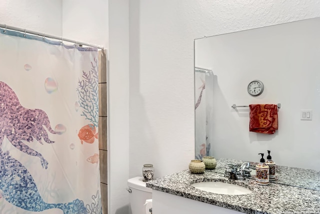bathroom with toilet, a shower with shower curtain, and vanity