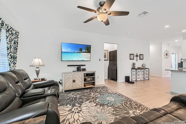 living area featuring ceiling fan, light wood finished floors, recessed lighting, baseboards, and visible vents
