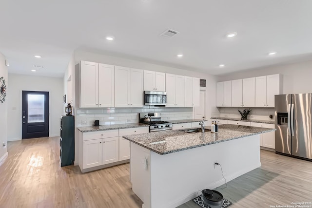 kitchen with a sink, stainless steel appliances, and light wood-type flooring
