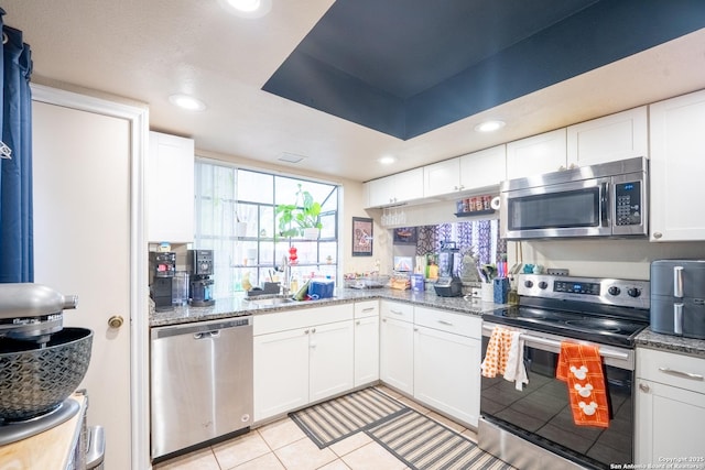 6405 Honey Hill, San Antonio, TX 78229 - kitchen featuring stainless steel appliances, light tile patterned floors, white cabinetry, and a sink