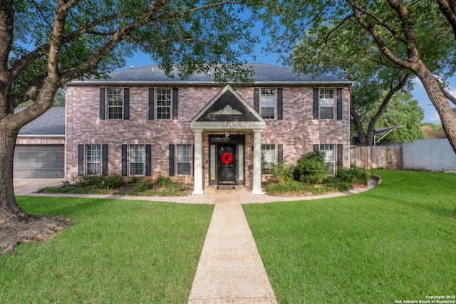 view of front of home featuring a front yard, brick siding, fence, an attached garage, and a shingled roof