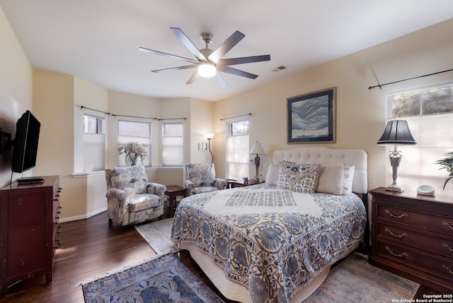 bedroom featuring baseboards, a ceiling fan, wood finished floors, and visible vents