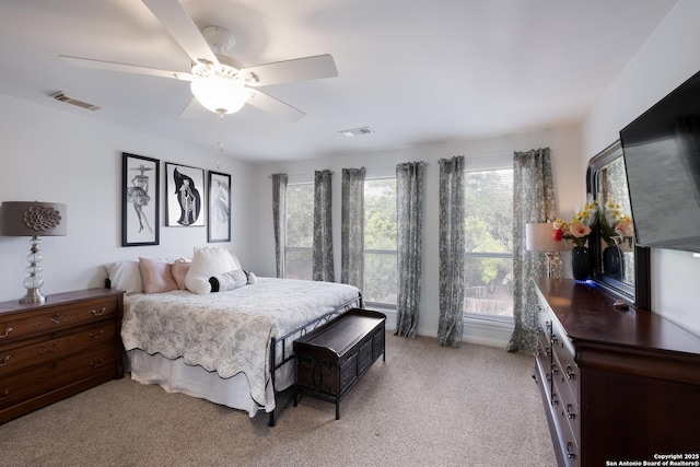 bedroom with ceiling fan, visible vents, and light carpet