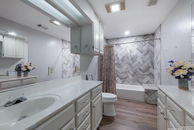 full bathroom featuring toilet, visible vents, shower / tub combo, and vanity