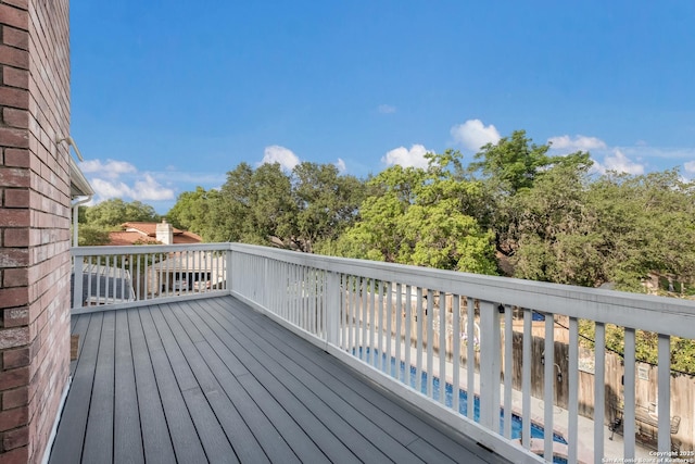 wooden deck with an outdoor pool and fence