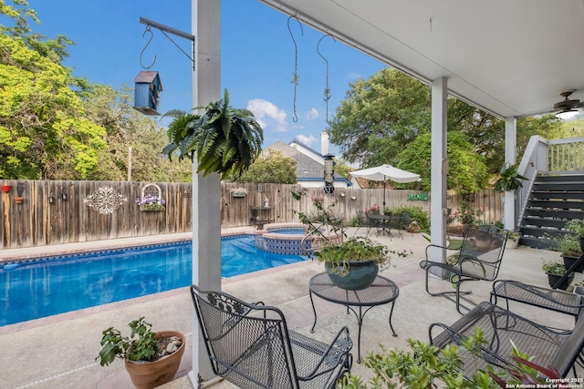 view of pool with a fenced backyard, a ceiling fan, a patio area, and stairway