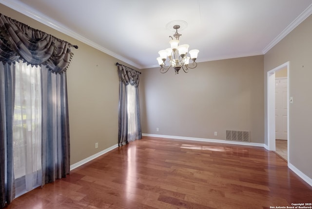 unfurnished room featuring visible vents, crown molding, wood finished floors, and a chandelier